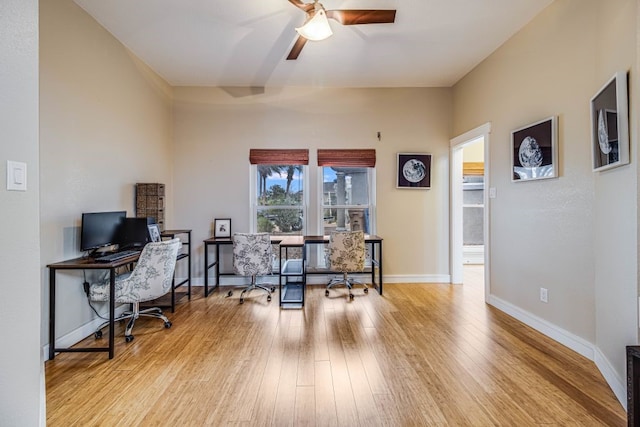 home office with ceiling fan and light hardwood / wood-style flooring