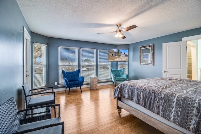 bedroom featuring a textured ceiling, wood-type flooring, and ceiling fan