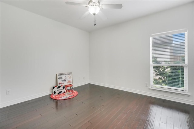 empty room featuring a ceiling fan, baseboards, and wood finished floors