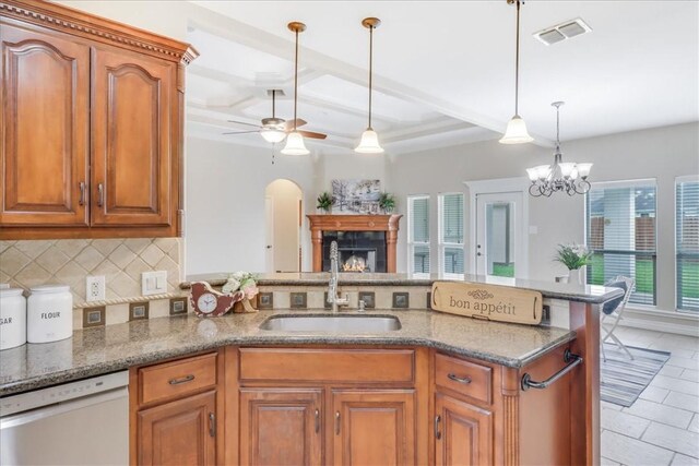 kitchen featuring visible vents, a sink, dishwashing machine, and brown cabinetry