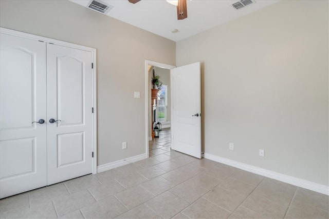 unfurnished bedroom featuring baseboards, visible vents, light tile patterned floors, and a closet