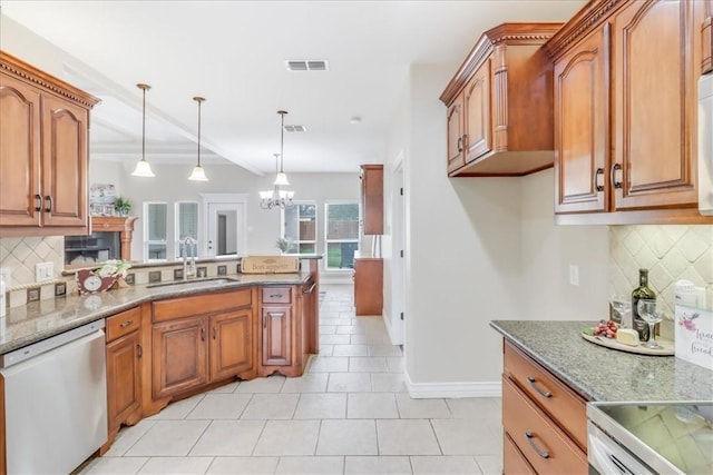 kitchen with visible vents, dishwasher, baseboards, a sink, and backsplash