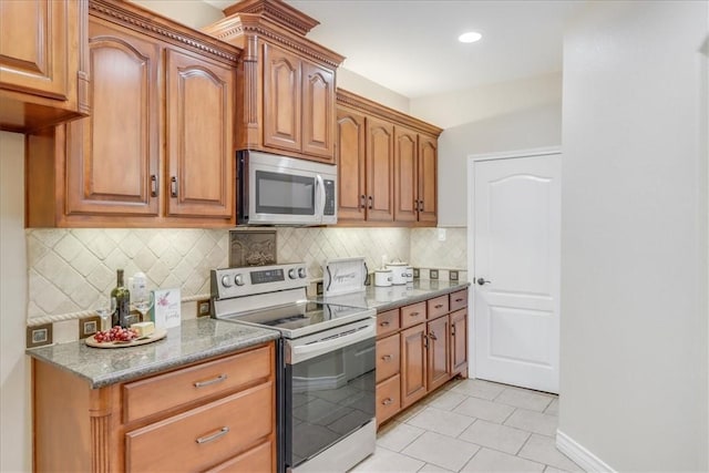 kitchen featuring backsplash, light tile patterned floors, light stone countertops, and stainless steel appliances