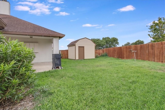 view of yard with a fenced backyard, an outdoor structure, and a shed