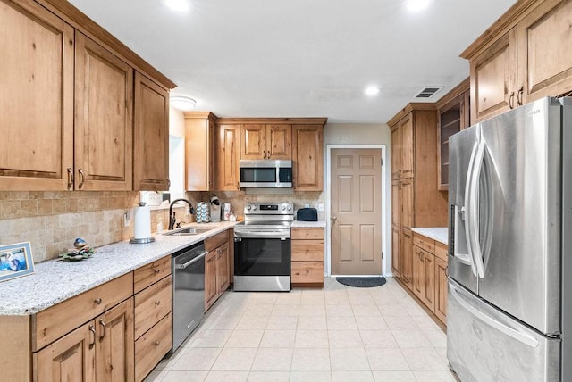 116 Greenway Ln, Rockport, TX 78382 - kitchen featuring appliances with stainless steel finishes, decorative backsplash, recessed lighting, light tile patterned flooring, and light stone countertops