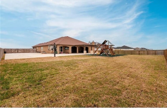 2013 Magnolia Falls Dr, Corpus Christi, TX 78415 - rear view of property with a fenced backyard, a playground, a lawn, and a patio area