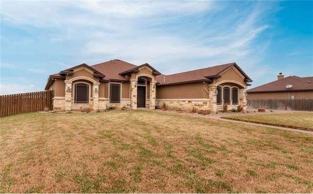 2013 Magnolia Falls Dr, Corpus Christi, TX 78415 - view of front of property featuring stone siding, an attached garage, fence, and a front yard