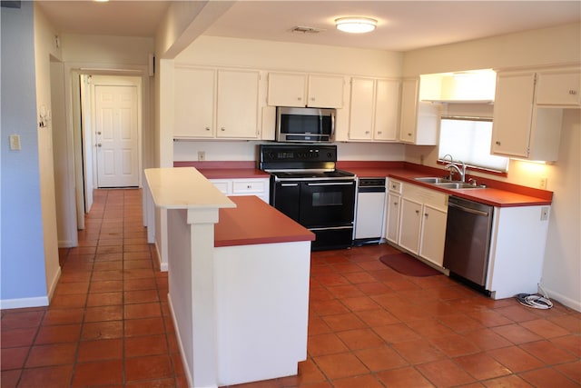 kitchen featuring stainless steel appliances, white cabinets, sink, and dark tile patterned flooring