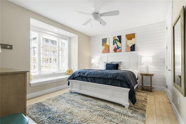 bedroom featuring light wood-style flooring, a ceiling fan, and baseboards