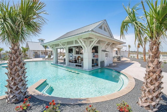 community pool with a patio area, fence, and a gazebo