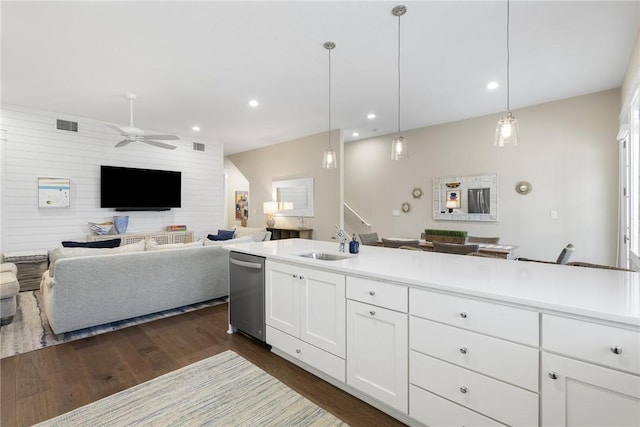 kitchen with white cabinets, open floor plan, light countertops, pendant lighting, and a sink