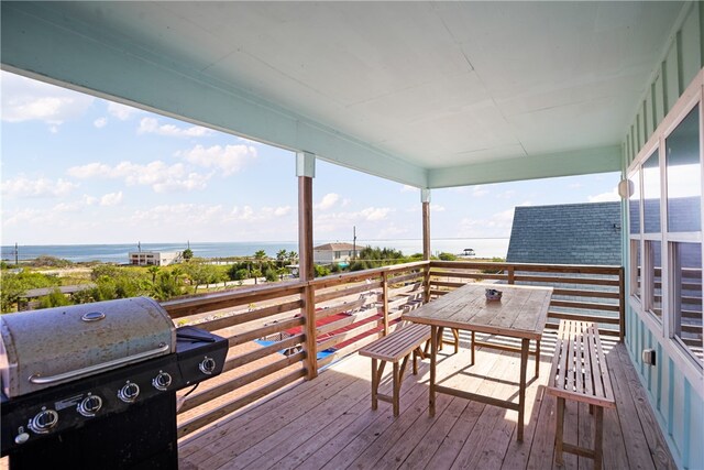 deck with grilling area and a water view