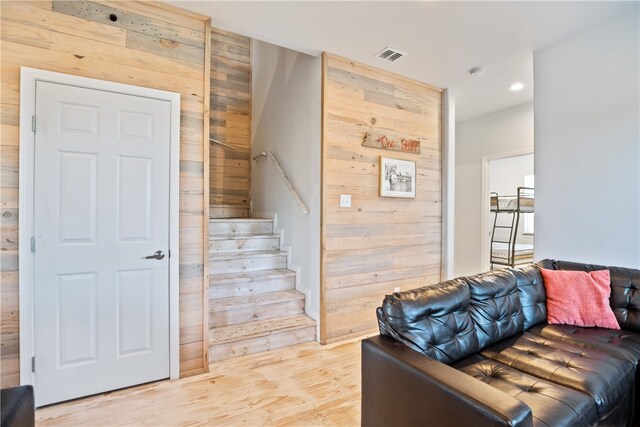 interior space with wooden walls and light hardwood / wood-style flooring