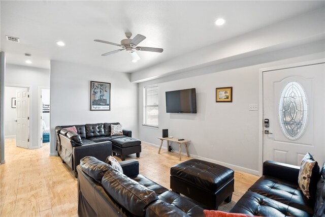 living room with light hardwood / wood-style flooring and ceiling fan