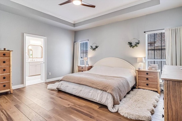 6046 Tarafaya Dr, Corpus Christi, TX 78414 - bedroom featuring wood finished floors, ensuite bathroom, a raised ceiling, and a ceiling fan