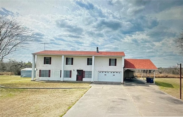 801 NE Frontage Rd, Beeville, TX 78102 - view of front of home featuring concrete driveway, a front yard, an attached garage, and a carport