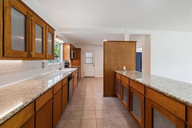 1009 Driftwood Pl, Corpus Christi, TX 78411 - kitchen with brown cabinetry, decorative backsplash, and glass insert cabinets