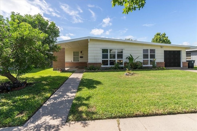 1009 Driftwood Pl, Corpus Christi, TX 78411 - view of front facade with brick siding, a garage, a front lawn, and driveway