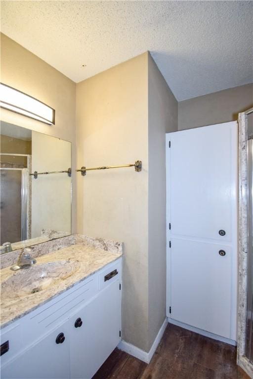 4410 Hebert, Corpus Christi, TX 78413 - bathroom featuring vanity, a textured ceiling, baseboards, and wood finished floors