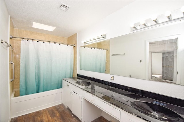 4410 Hebert, Corpus Christi, TX 78413 - full bath featuring a textured ceiling, visible vents, wood finished floors, a sink, and shower / tub combo with curtain