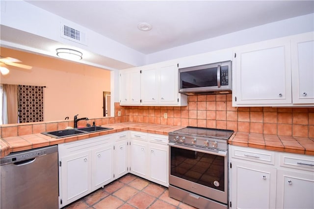 4410 Hebert, Corpus Christi, TX 78413 - kitchen with a sink, tasteful backsplash, appliances with stainless steel finishes, and white cabinets