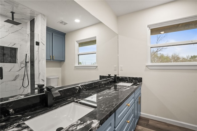 bathroom featuring hardwood / wood-style flooring, vanity, toilet, and a shower with shower door