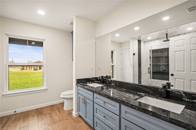 bathroom featuring vanity, hardwood / wood-style floors, toilet, and walk in shower