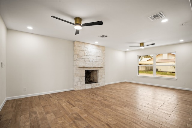 unfurnished living room with ceiling fan, a fireplace, and light hardwood / wood-style floors