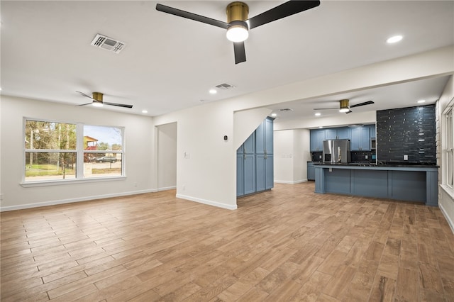 unfurnished living room with ceiling fan and light hardwood / wood-style floors