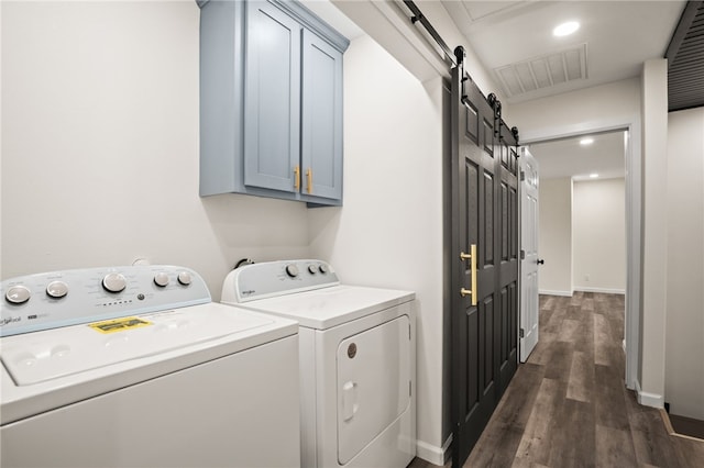 laundry area with independent washer and dryer, cabinets, a barn door, and dark hardwood / wood-style flooring