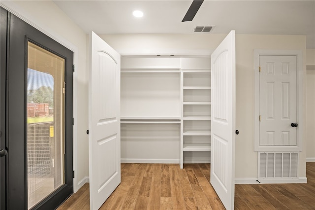 walk in closet featuring wood-type flooring and ceiling fan