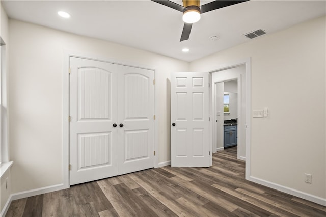 unfurnished bedroom with ceiling fan, dark hardwood / wood-style flooring, and a closet