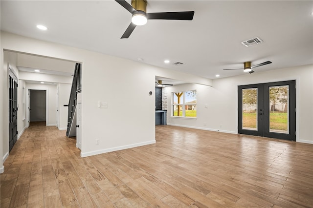 empty room with light hardwood / wood-style floors, french doors, and ceiling fan