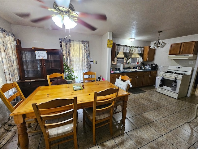 dining room featuring ceiling fan with notable chandelier, a textured ceiling, and sink