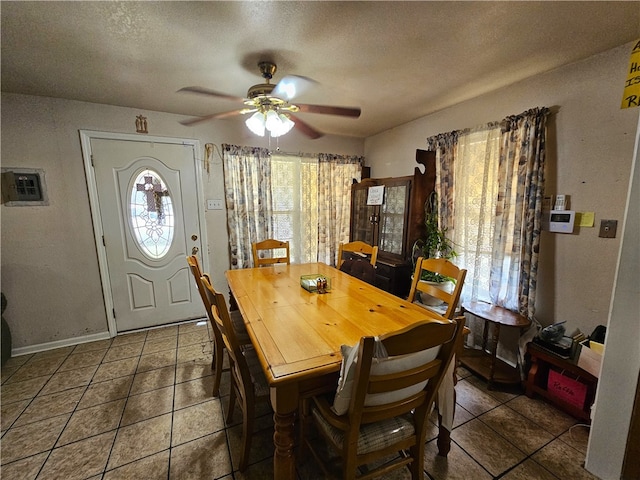 tiled dining area featuring a textured ceiling and ceiling fan