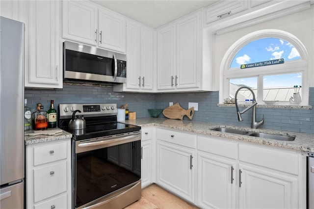 109 Tarpon Ct, Aransas Pass, TX 78336 - kitchen with appliances with stainless steel finishes, a sink, white cabinetry, and tasteful backsplash