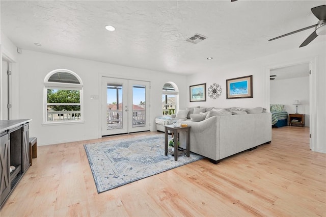 109 Tarpon Ct, Aransas Pass, TX 78336 - living room featuring a ceiling fan, plenty of natural light, light wood-style floors, french doors, and a textured ceiling