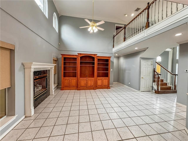 4513 Ammer Lake Dr, Corpus Christi, TX 78413 - unfurnished living room with a high ceiling, a ceiling fan, stairway, a high end fireplace, and crown molding