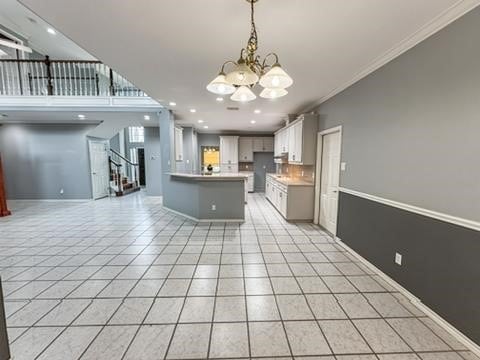 4513 Ammer Lake Dr, Corpus Christi, TX 78413 - kitchen with a chandelier, open floor plan, crown molding, light tile patterned floors, and a peninsula