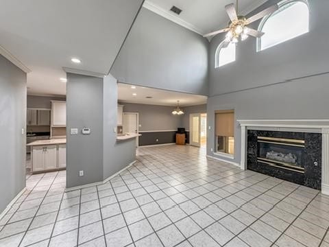 4513 Ammer Lake Dr, Corpus Christi, TX 78413 - unfurnished living room featuring ornamental molding, a high end fireplace, a ceiling fan, light tile patterned floors, and recessed lighting