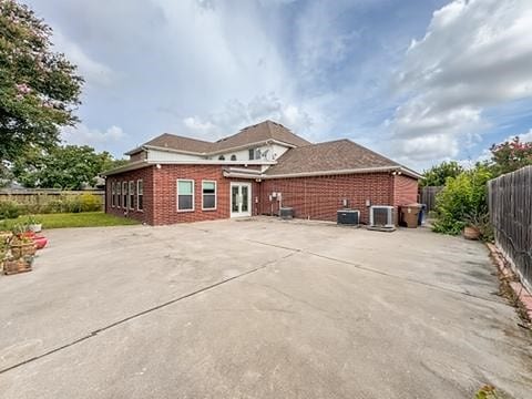 4513 Ammer Lake Dr, Corpus Christi, TX 78413 - rear view of house with a fenced backyard, brick siding, a patio, and french doors