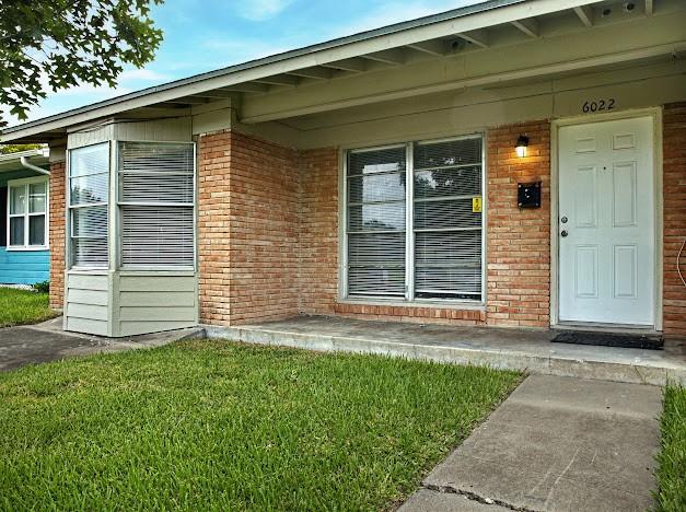 6022 Norvel Dr, Corpus Christi, TX 78412 - doorway to property with brick siding and a yard