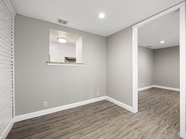 6022 Norvel Dr, Corpus Christi, TX 78412 - spare room featuring wood finished floors, recessed lighting, and brick wall