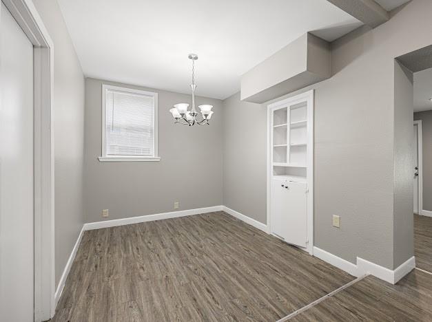 6022 Norvel Dr, Corpus Christi, TX 78412 - empty room featuring dark wood-style floors and a chandelier