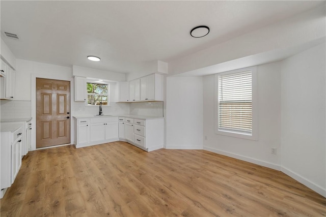 2442 Bevecrest Dr, Corpus Christi, TX 78415 - kitchen with light countertops, visible vents, light wood finished floors, baseboards, and tasteful backsplash
