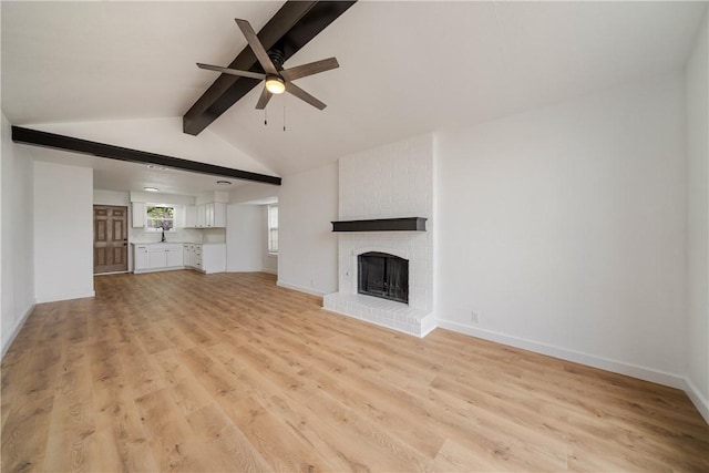 2442 Bevecrest Dr, Corpus Christi, TX 78415 - unfurnished living room featuring a brick fireplace, baseboards, ceiling fan, light wood-type flooring, and vaulted ceiling with beams