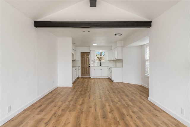 2442 Bevecrest Dr, Corpus Christi, TX 78415 - unfurnished living room featuring lofted ceiling with beams, baseboards, and light wood-style floors