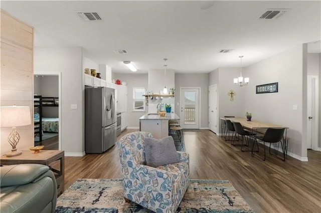 living room with dark hardwood / wood-style flooring and a chandelier