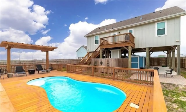 view of pool featuring a deck and a shed