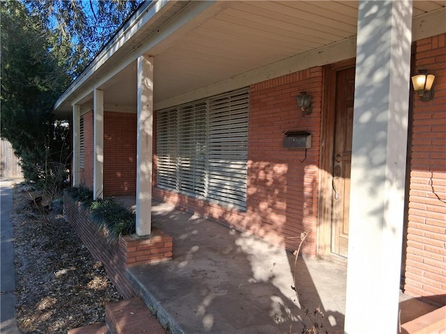 view of exterior entry featuring brick siding